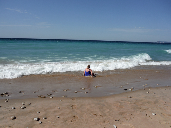 Karen Duquette sits on the shoreline of Lake Michigan